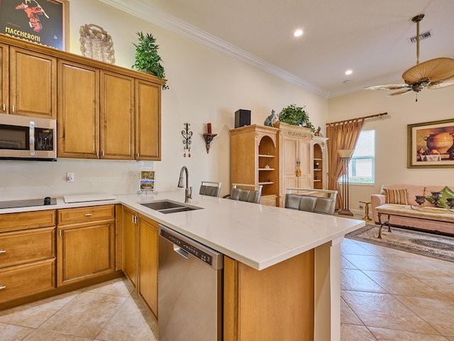 kitchen featuring kitchen peninsula, stainless steel appliances, crown molding, sink, and light tile patterned flooring