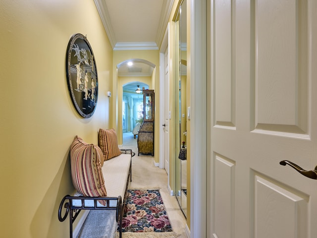 hall with crown molding and light carpet