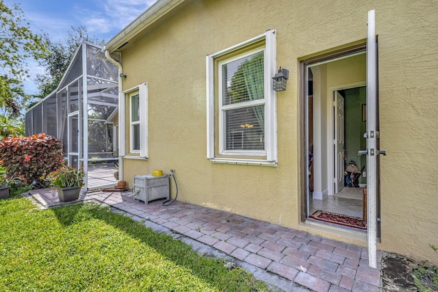 view of exterior entry featuring a lawn