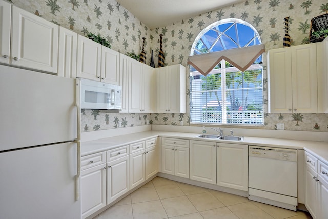 kitchen featuring white cabinetry, white appliances, sink, and light tile patterned floors