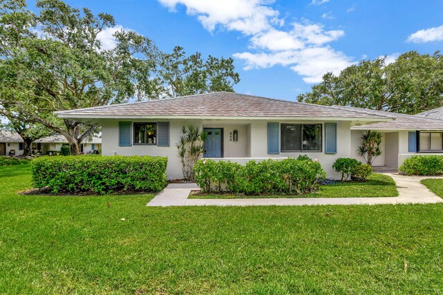 ranch-style home featuring a front lawn