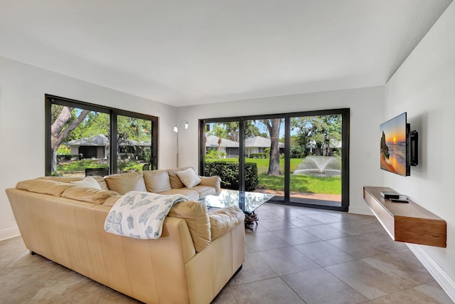 living room with a healthy amount of sunlight, baseboards, and light tile patterned floors