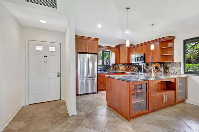 kitchen with light tile patterned flooring, decorative backsplash, stainless steel appliances, and dark stone countertops