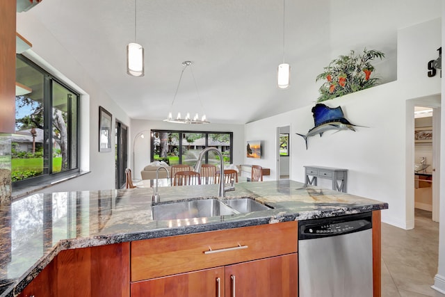 kitchen featuring stainless steel dishwasher, sink, pendant lighting, dark stone counters, and light tile patterned flooring