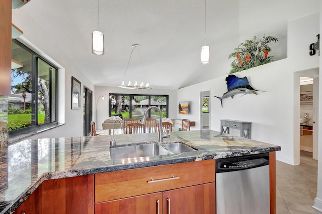 kitchen with dark stone countertops, open floor plan, hanging light fixtures, and stainless steel dishwasher