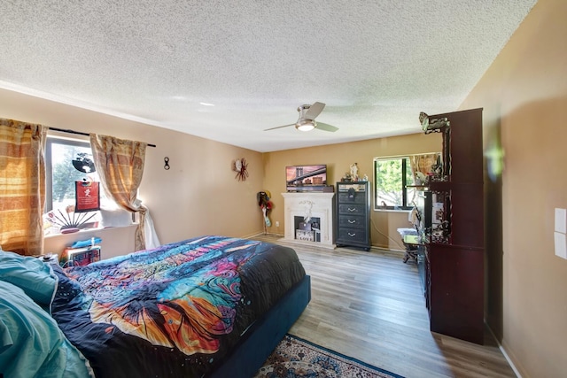 bedroom featuring a textured ceiling, ceiling fan, and wood-type flooring