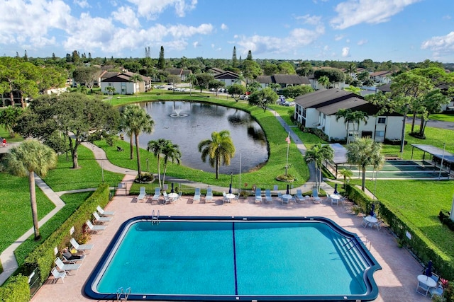 view of pool featuring a water view and a yard