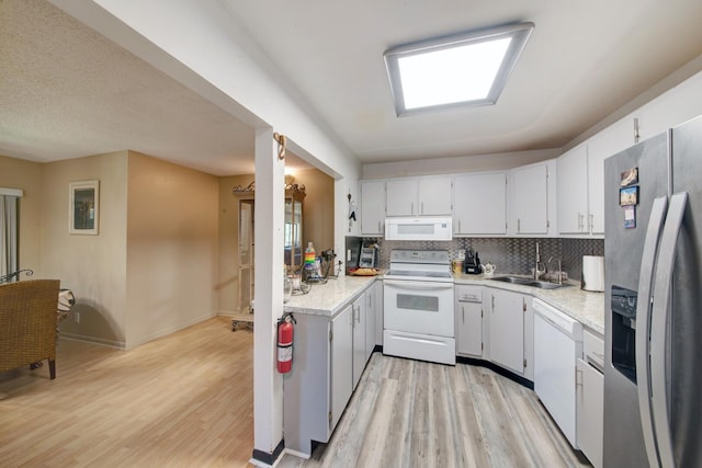 kitchen with light hardwood / wood-style flooring, decorative backsplash, white cabinetry, sink, and white appliances