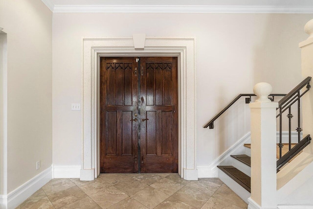 entrance foyer featuring stairway, baseboards, and ornamental molding