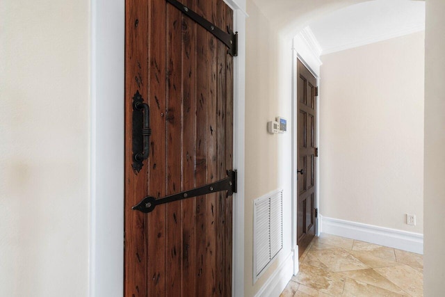 corridor with ornamental molding, arched walkways, visible vents, and baseboards