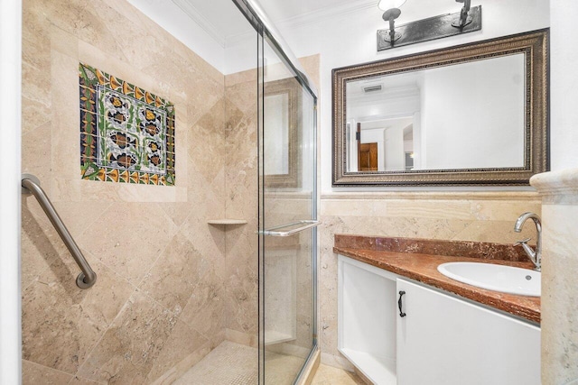 bathroom featuring visible vents, vanity, tile walls, a shower stall, and crown molding