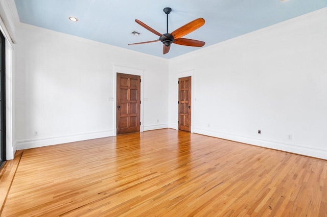 empty room featuring ornamental molding, light wood-style flooring, and visible vents