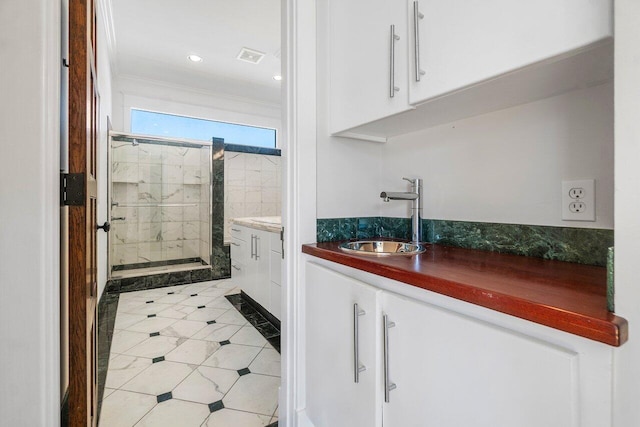 bathroom with a stall shower, visible vents, ornamental molding, vanity, and recessed lighting