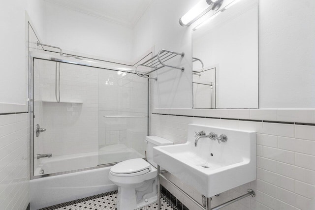 full bath featuring toilet, a sink, tile walls, and crown molding