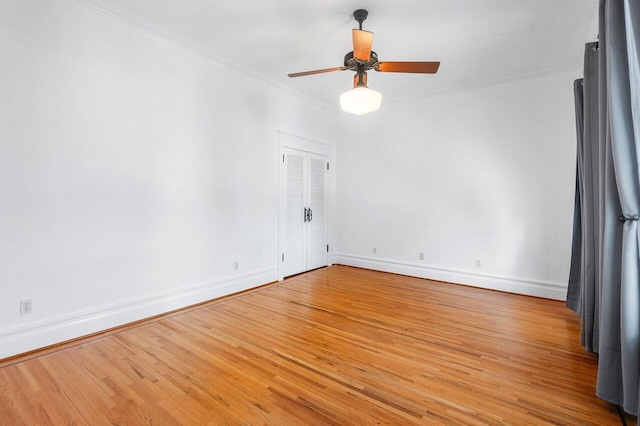 spare room with ornamental molding, ceiling fan, baseboards, and wood finished floors