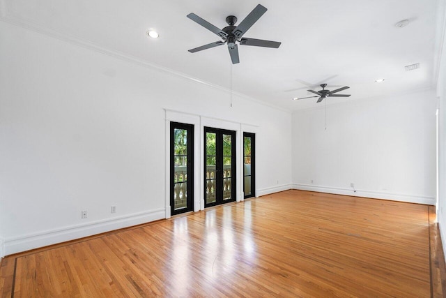 empty room with baseboards, visible vents, ornamental molding, and wood finished floors