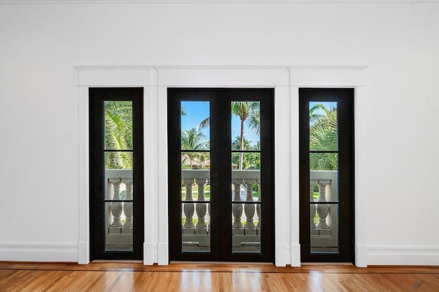 doorway with wood finished floors and baseboards