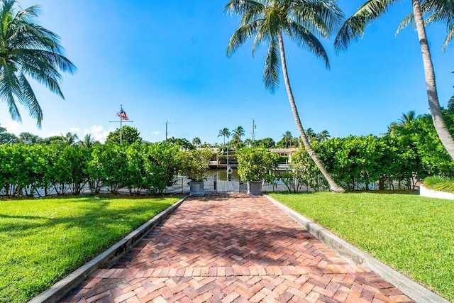 view of community featuring a lawn and fence