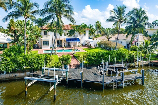 dock area featuring boat lift, a water view, a patio area, fence, and an outdoor pool