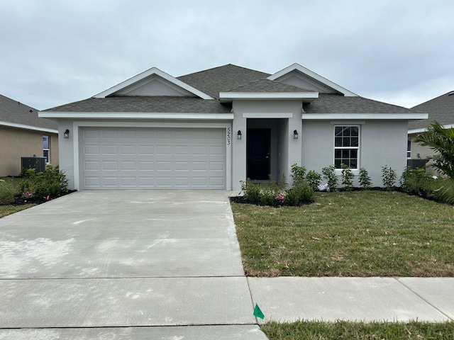 view of front of property with a garage, central air condition unit, and a front yard