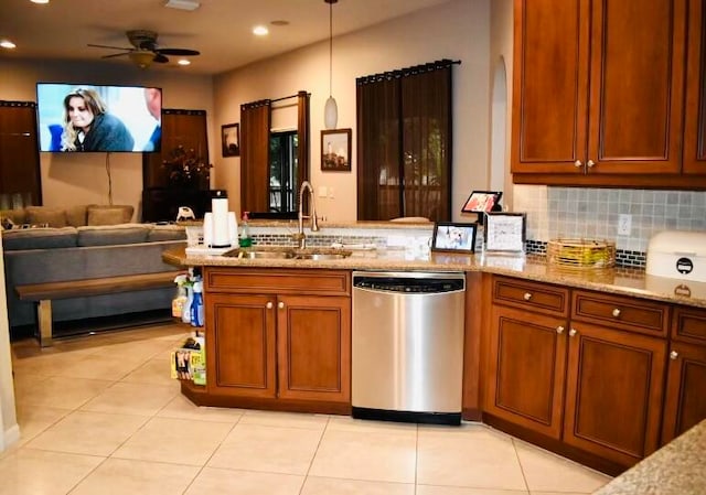 kitchen featuring sink, decorative backsplash, light stone countertops, stainless steel dishwasher, and ceiling fan