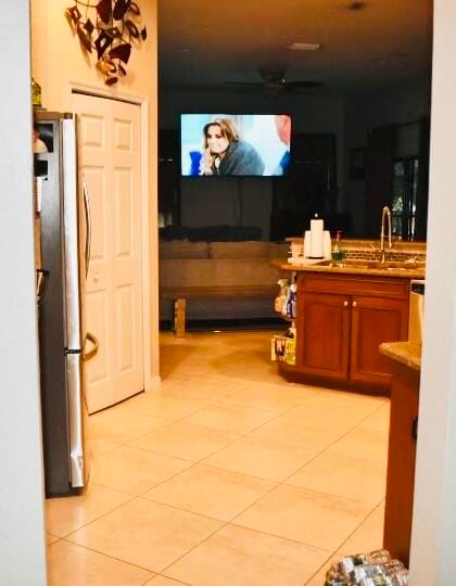 kitchen with light tile patterned floors, sink, and stainless steel refrigerator