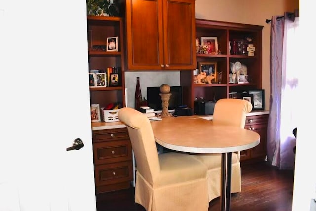 home office featuring built in desk and dark hardwood / wood-style flooring