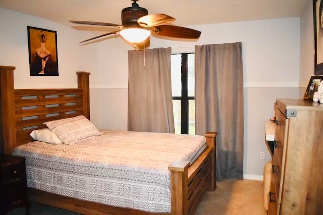 tiled bedroom with ceiling fan and multiple windows