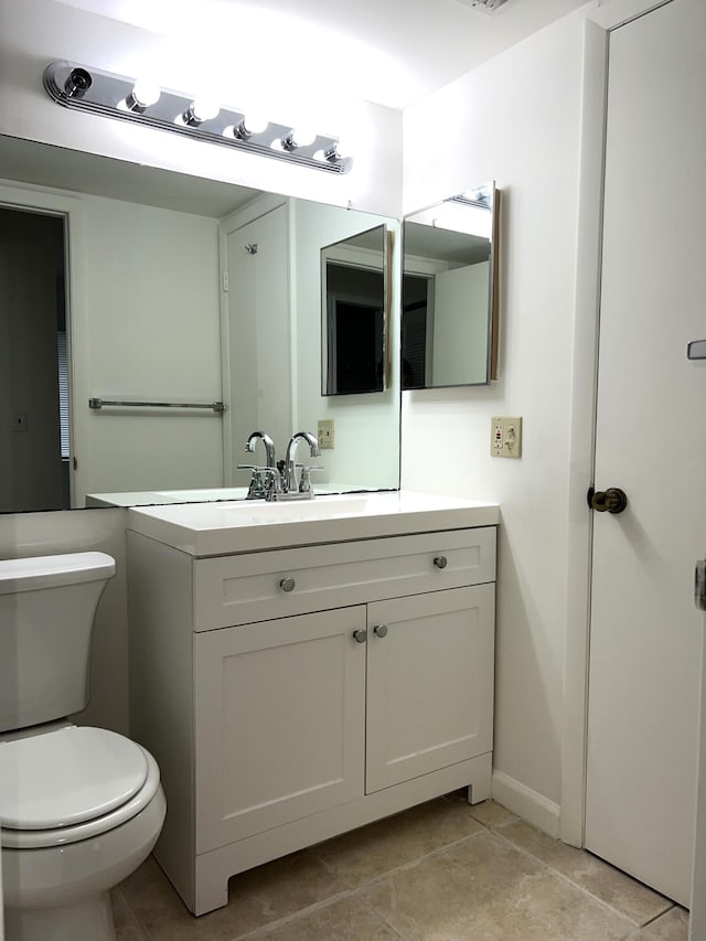 bathroom featuring tile patterned flooring, vanity, and toilet