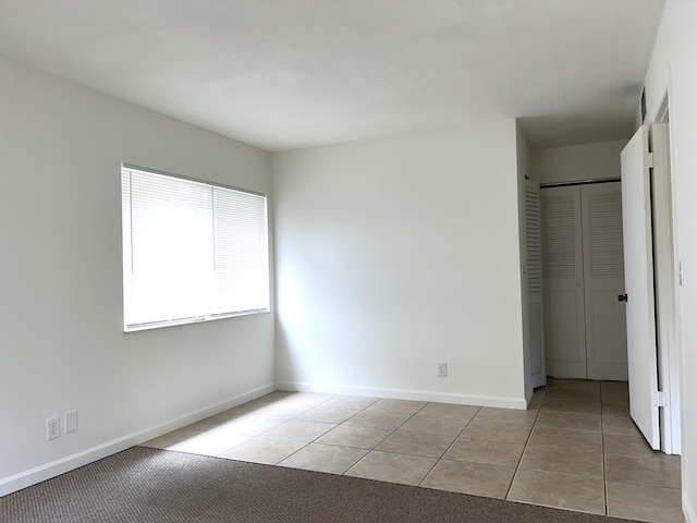 unfurnished bedroom featuring a closet and light tile patterned floors