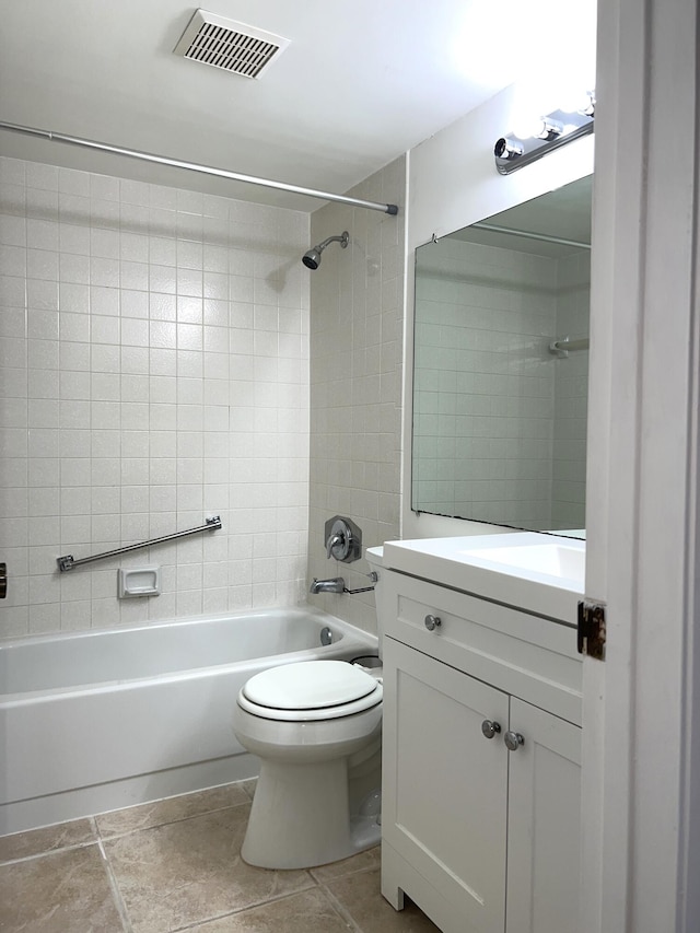 full bathroom featuring tile patterned flooring, toilet, tiled shower / bath combo, and vanity