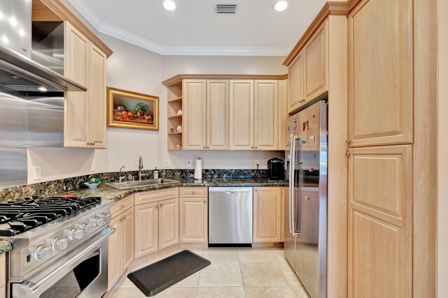 kitchen featuring ornamental molding, light brown cabinetry, light tile patterned floors, stainless steel appliances, and wall chimney range hood