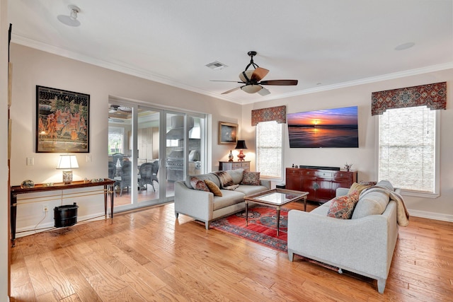 living room with a wealth of natural light, light wood-type flooring, crown molding, and ceiling fan