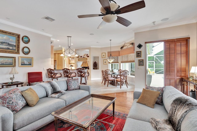 living room featuring ceiling fan, crown molding, and light hardwood / wood-style floors