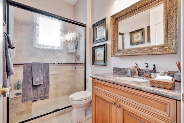 bathroom featuring tile patterned flooring, toilet, an enclosed shower, and vanity