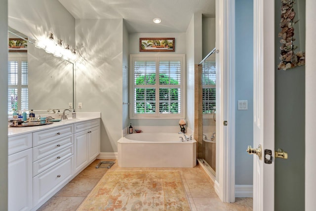 bathroom with tile patterned flooring, a tub, a textured ceiling, and vanity