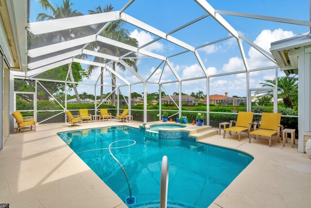 view of pool with glass enclosure, an in ground hot tub, and a patio area