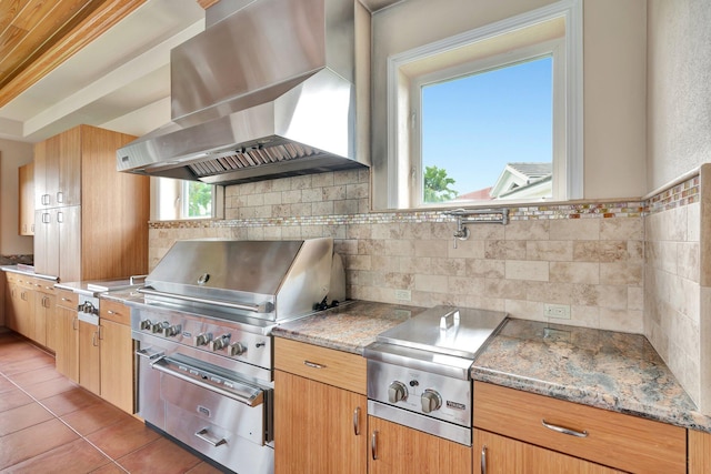 kitchen with backsplash, ventilation hood, and dark tile patterned floors