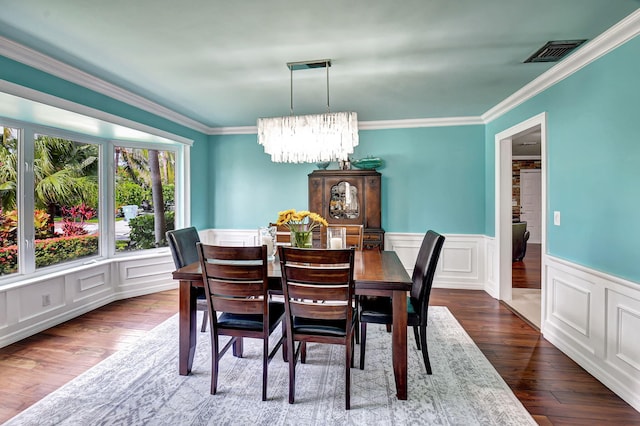 dining area featuring wood-type flooring, visible vents, a notable chandelier, and ornamental molding