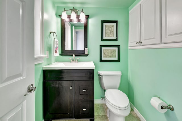 bathroom with toilet, baseboards, and vanity