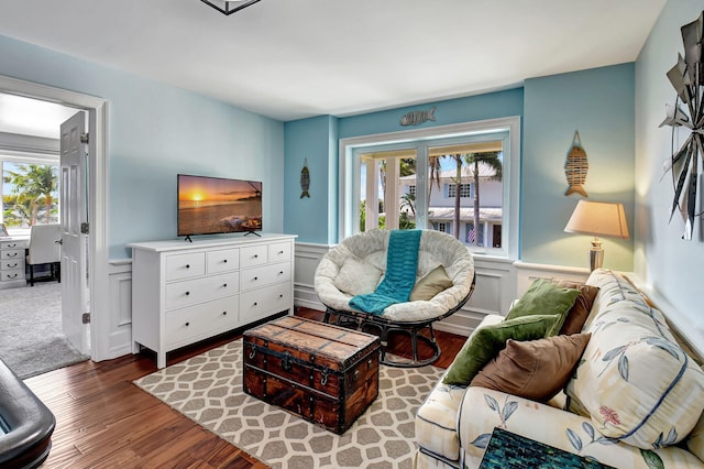 living room featuring a wainscoted wall and wood finished floors