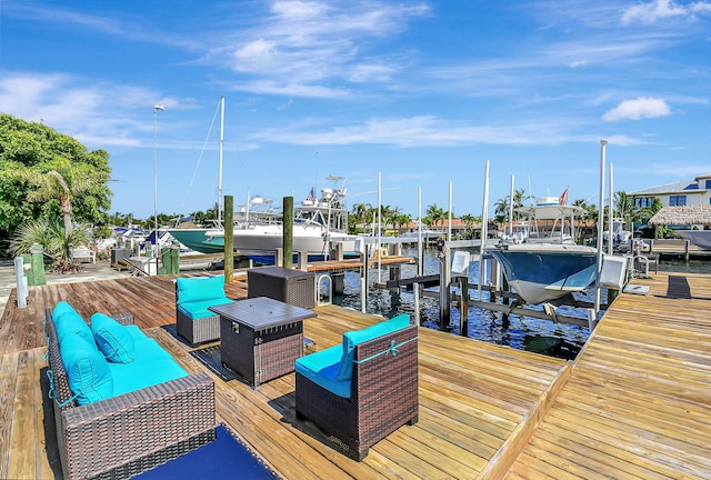 view of dock featuring a water view, boat lift, and an outdoor living space