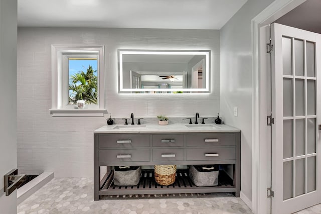 full bathroom with double vanity, a sink, a ceiling fan, and decorative backsplash