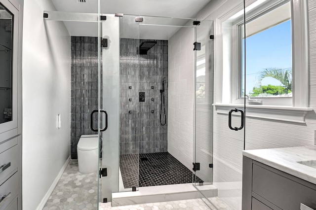 full bath featuring toilet, a shower stall, baseboards, and vanity