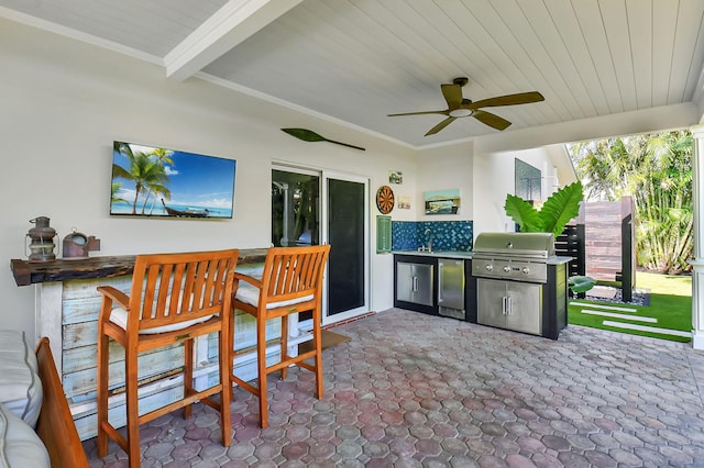 view of patio with ceiling fan, outdoor wet bar, an outdoor kitchen, and area for grilling