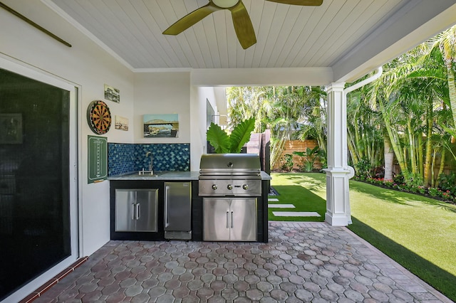 view of patio featuring area for grilling, an outdoor kitchen, ceiling fan, a sink, and fence