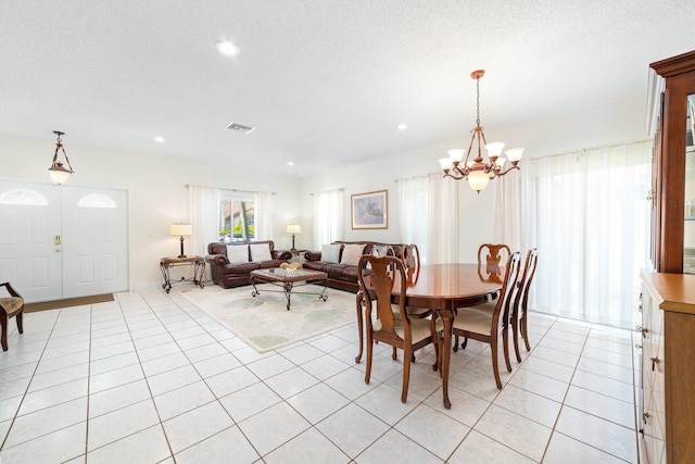 dining space featuring light tile patterned flooring, an inviting chandelier, and a textured ceiling