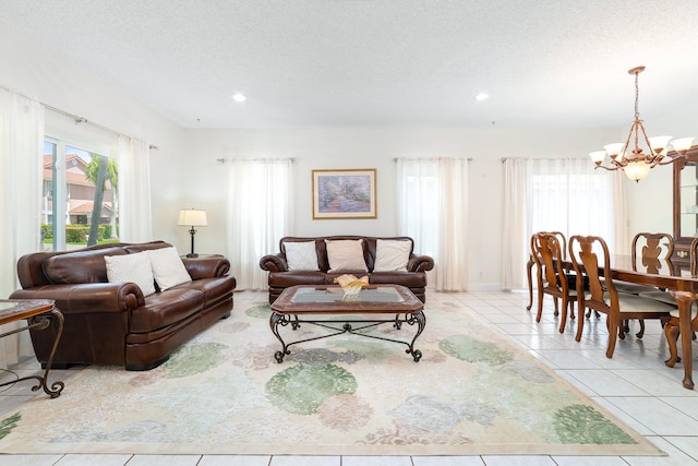 living room with a textured ceiling, a chandelier, and light tile patterned floors