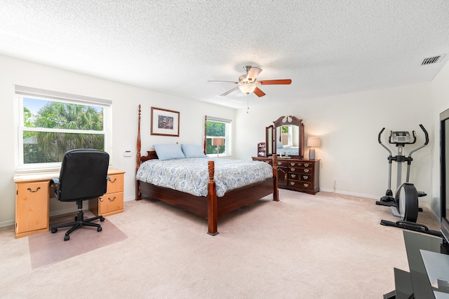 carpeted bedroom featuring a textured ceiling and ceiling fan