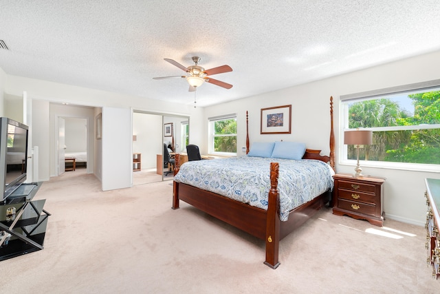 carpeted bedroom featuring a textured ceiling, a closet, and ceiling fan